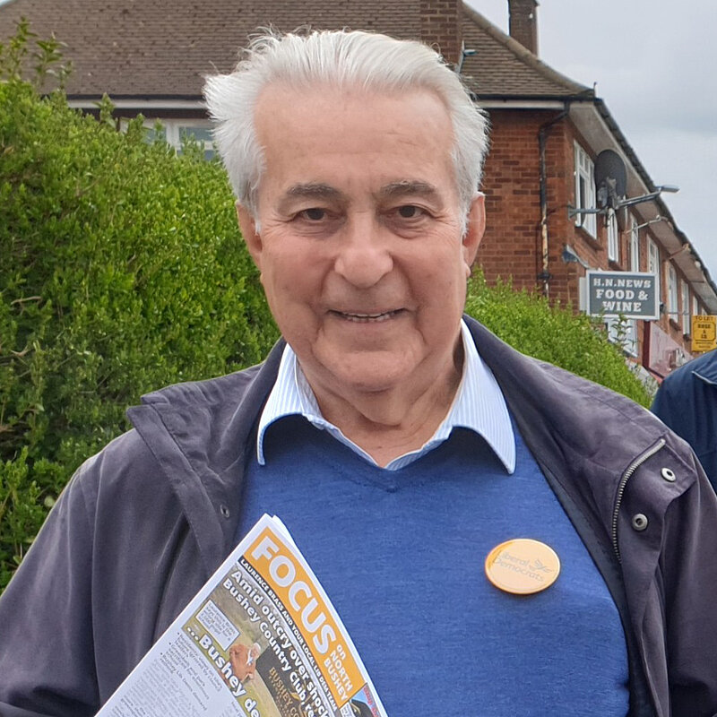 Laurence Brass on Park Avenue in Bushey with a Lib Dem badge and a Focus newsletter