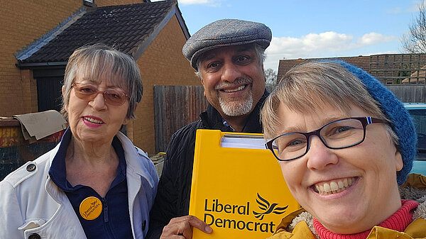 Three Lib Dem volunteers with a yellow clip board