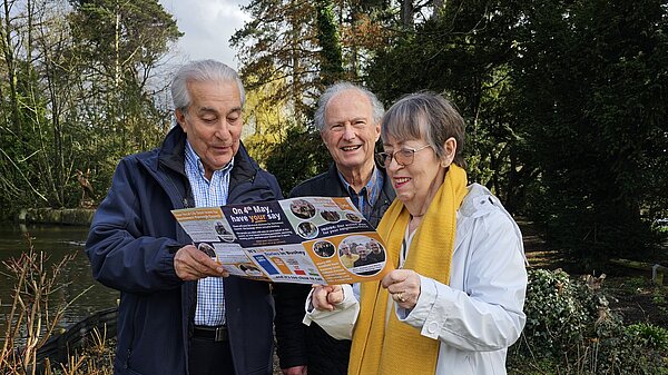Three residents reading a Lib Dem newsletter